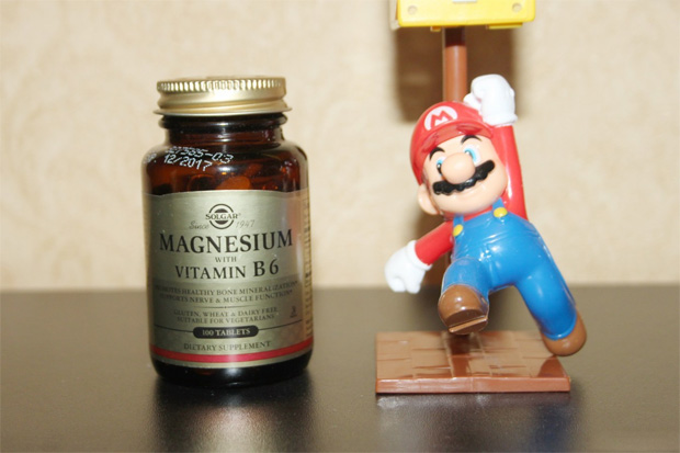 Баночка с препаратом Магний Б6 рядом с фигуркой Марио