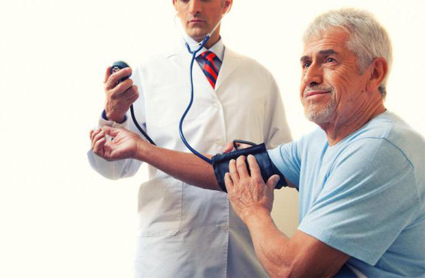 Врач измеряет пожилому мужчине артериальное давление